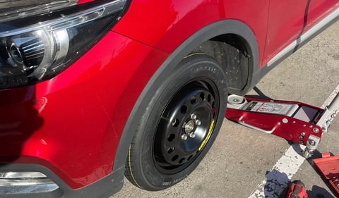 Red vehicle connected to a red car trailer on a concrete surface