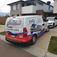 Red and white service van parked in a residential driveway with a two-story house in the background
